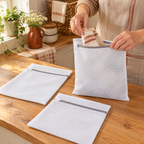 Nest Mesh Laundry Bag Trio use: One Nest pouch being filled with socks, with two matching bags nearby