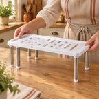 Second Shelf Cabinet Riser use: Two hands gently adjusting the width of an empty Second Shelf riser
