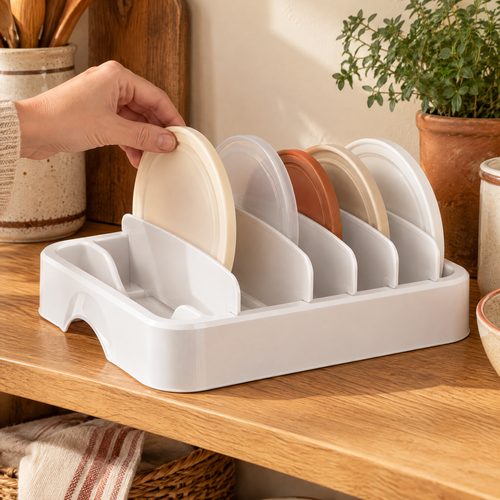 Together Lid Organizer use: One hand choosing a lid from the complete Together organizer