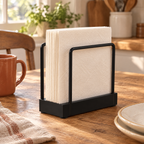 Welcome Napkin Holder story: Welcome holder keeping plain cream paper napkins together beside a small kitchen table setting
